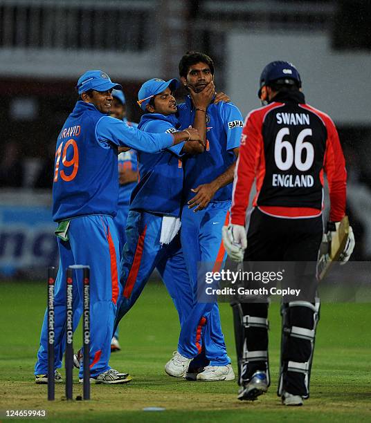 Munaf Patel of India celebrates with team mates Suresh Raina and Rahul Dravid after a direct hit to run out Graeme Swann of England during the 4th...