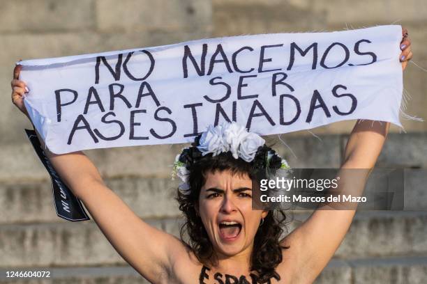 Activist of feminist group FEMEN holds a banner reading "We are not born to be killed" protesting against the increase in gender-based murder of...