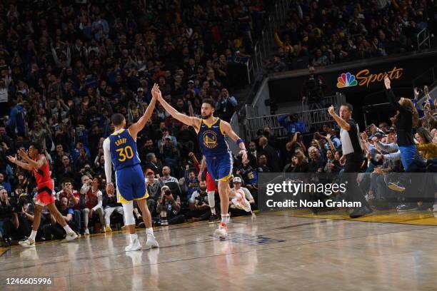 Teammates Stephen Curry of the Golden State Warriors and Klay Thompson high five during the game against the Toronto Raptors on January 27, 2023 at...