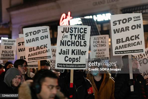 Protesters hold placards demanding justice following the...