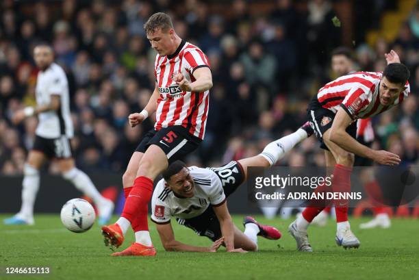 Fulham's Brazilian striker Carlos Vinicius falls to the ground after a challenge by Sunderland's English defender Danny Batth , while Sunderland's...
