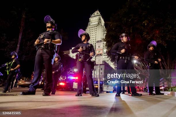 Los Angeles Police officers stand should to shoulder wearing riot gear near City Hall after crowds became unruly after a vigil for Tyre Nichols near...