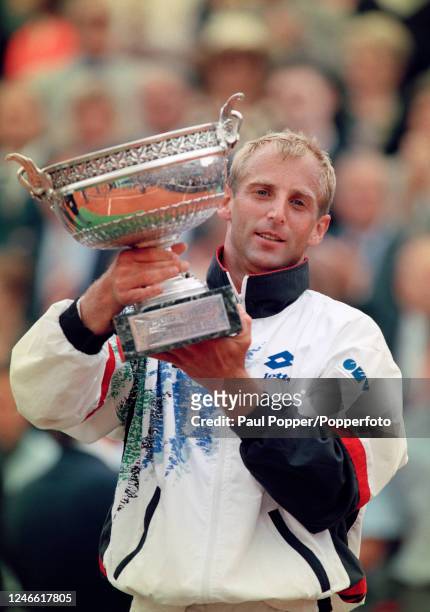 Thomas Muster of Austria celebrates with the trophy after defeating Michael Chang of the United States in the men's singles final on day fourteen of...