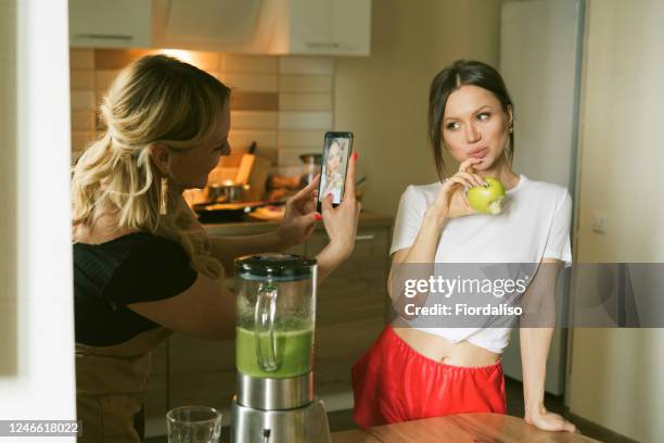 two woman having  breakfast - fruit smoothie instagram stock-fotos und bilder