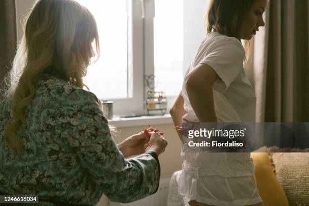 woman helps girl to get dressed, to fasten a pin
hairstyle to a woman - quarantine wedding stock pictures, royalty-free photos & images