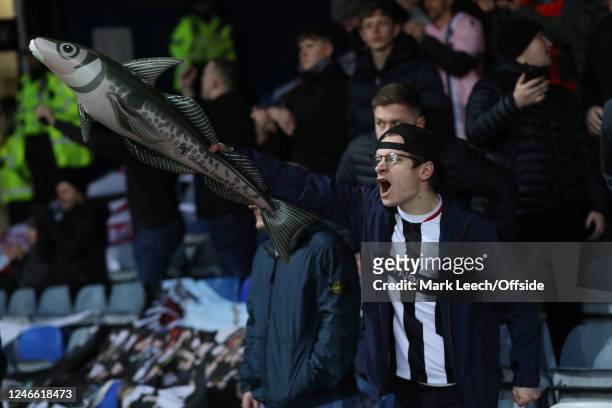 A Grimsby Town fan celebrates holding an inflatable haddock during the Emirates FA Cup match between Luton Town and Grimsby Town at Kenilworth Road...