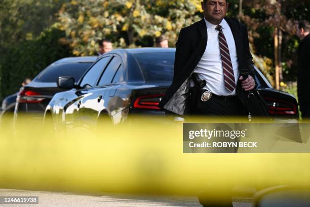 Detective walks at the scene of an investigation after an early morning shooting that left three people dead and four wounded in the Beverly Crest...