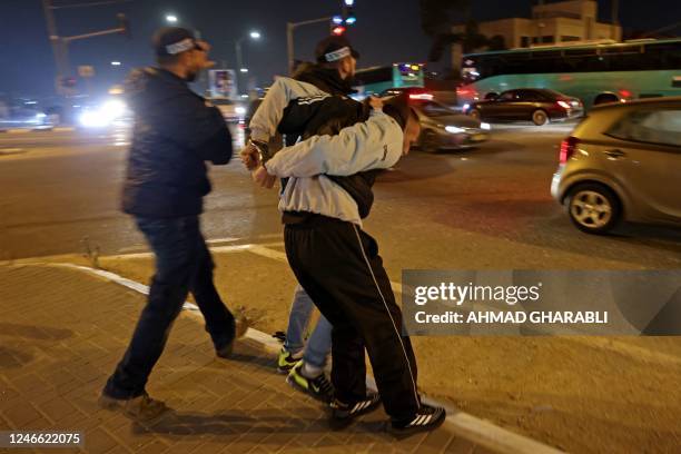 Israeli security forces detain a Palestinian in east Jerusalem's Shuafat refugee camp on January 28, 2023 as Israelis protest following two attacks...