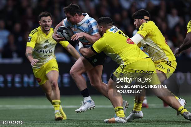 Racing92's French centre Henry Chavancy tries to avoid the tackle of La Rochelle's Argentinian prop Joel Sclavi during the French Top14 rugby union...