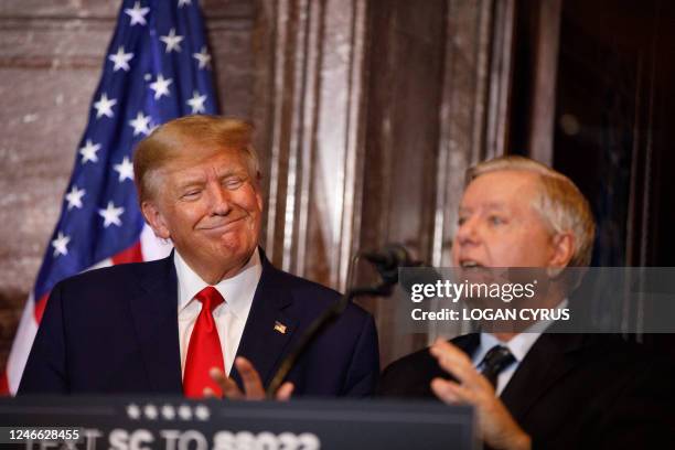Former US President Donald Trump gestures as US Senator Lindsey Graham addresses the crowd during a 2024 election campaign event in Columbia, South...