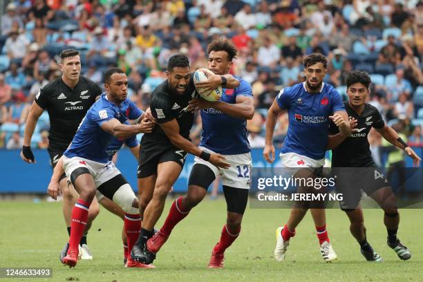 Sione Molia of New Zealand is tackled in the match between New Zealand and France during the World Rugby Sevens series match at the Allianz Stadium...