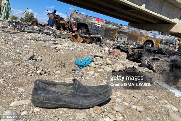 Resident looks at the wreckage of a burnt passenger bus at Bela in Lasbela district of Pakistan's Balochistan province on January 29, 2023. - At...