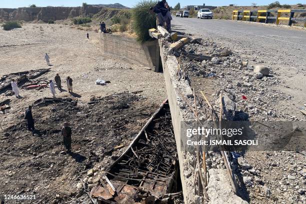 Residents look at the wreckage of a burnt passenger bus at Bela in Lasbela district of Pakistan's Balochistan province on January 29, 2023. - At...