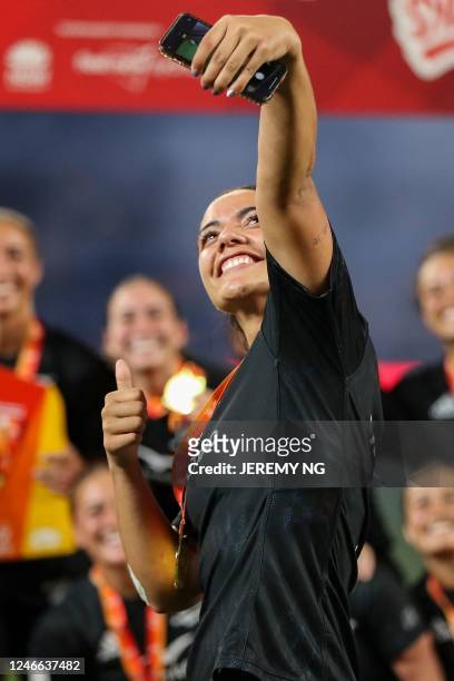 New Zealand player takes a selfie with her teammates as they celebrate winning the women's competition in the World Rugby Sevens series, at the...