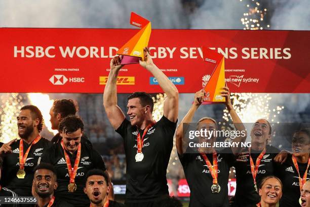 New Zealand's players celebrate with their trophies after winning both the men's and the women's competitions in the World Rugby Sevens series, at...