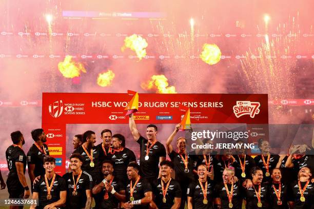 New Zealand's players celebrate with their trophies after winning both the men's and the women's competitions in the World Rugby Sevens series, at...