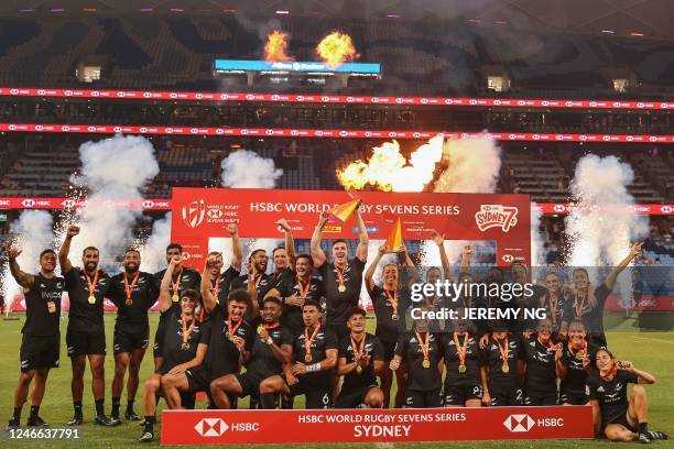 New Zealand's players celebrate with their trophies after winning both the men's and the women's competitions in the World Rugby Sevens series, at...