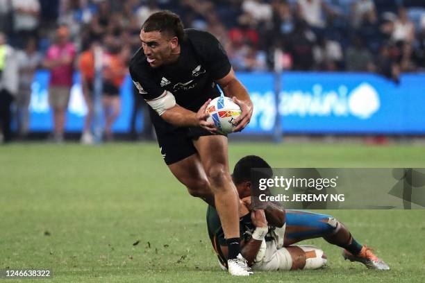 New Zealand's Joe Webber offloads during the World Rugby Sevens series final match between New Zealand and South Africa at the Allianz Stadium in...