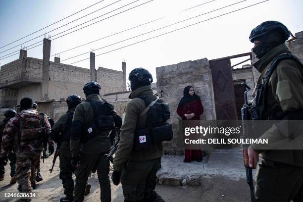 Syrian Kurdish Asayish security forces walks past a house during a raid against suspected Islamic State group fighters in Raqa, the jihadist group's...