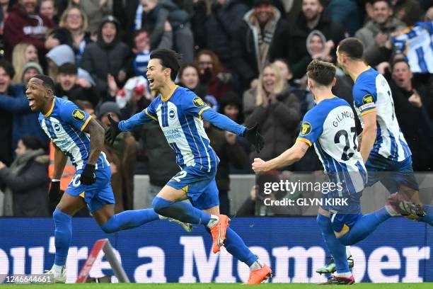 Brighton's Japanese midfielder Kaoru Mitoma celebrates with teammates after scoring their second goal during the English FA Cup fourth round football...