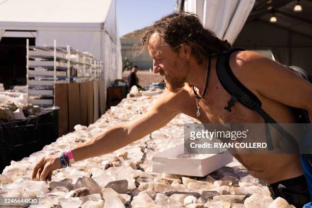 Craig Smith selects quartz crystals during the 22nd Street Mineral, Fossil, Gem and Jewelry Show in Tucson, Arizona, on January 28, 2023. - Craig...