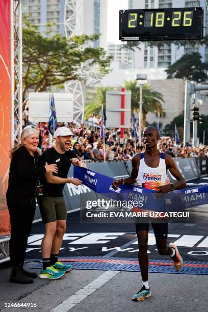 George Onyancha, of Grand Prairie, Texas, crosses the finish line to place first in the mens division of the Life Time Miami Marathon and Half in...