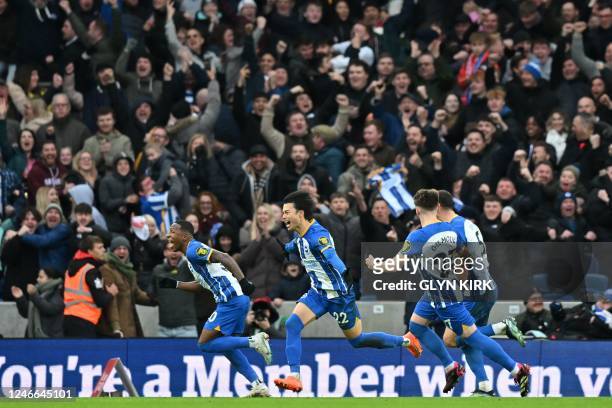 Brighton's Japanese midfielder Kaoru Mitoma celebrates with teammates after scoring their second goal during the English FA Cup fourth round football...
