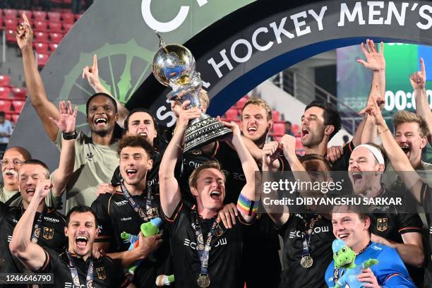 Germany's players celebrate with the trophy after winning the FIH men's Hockey World Cup 2023 final match against Belgium at the Kalinga Stadium in...