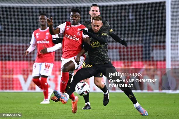 Paris Saint-Germain's Brazilian forward Neymar fights for the ball with Reims' English forward Folarin Balogun during the French L1 football match...