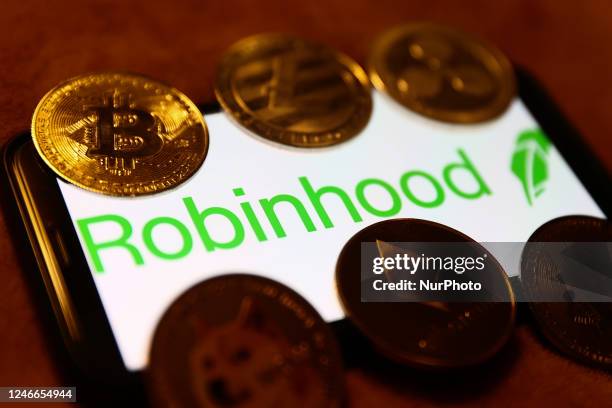 Robinhood logo displayed on a phone screen and representation of cryptocurrencies are seen in this illustration photo taken in Krakow, Poland on...