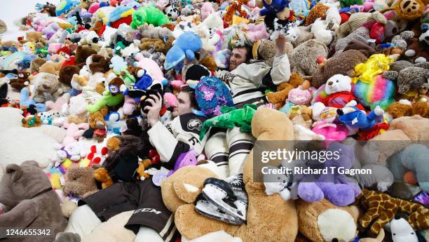 Dylan Mcilrath of the Hershey Bears and teammate Vincent Iorio jumps into a pile of teddy bears after an American Hockey League game during the...