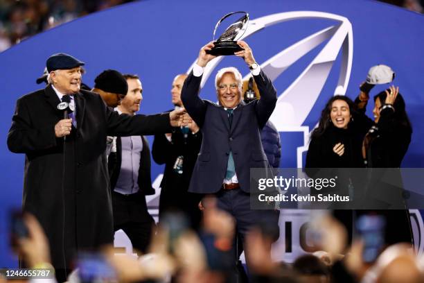 Owner Jeffrey Lurie of the Philadelphia Eagles lifts the George Halas Trophy on stage with Fox broadcaster and former NFL quarterback Terry Bradshaw...