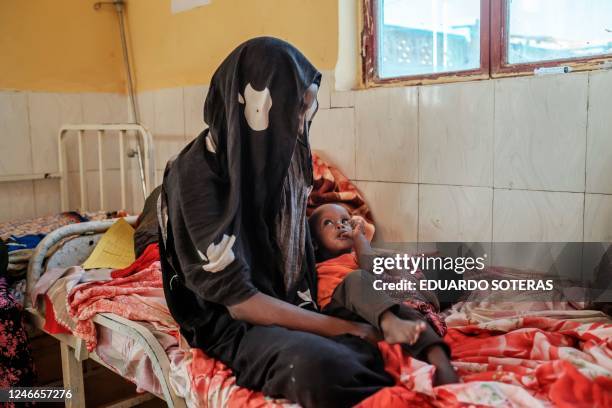 Woman holds a malnourished child at the nutrition unit of the Gode General Hospital, in the city of Gode, Ethiopia, on January 13, 2023. - The last...