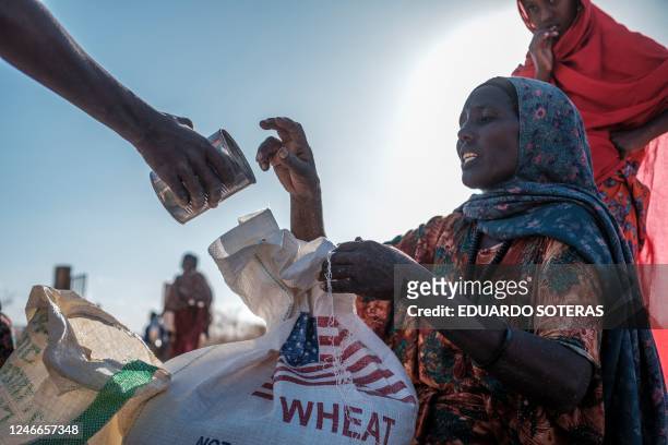 An internally displaced woman receives a can during a food distribution at Berley Camp, 20 kilometres from the city of Gode, Ethiopia, on January 10,...