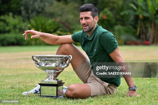 Serbia's Novak Djokovic celebrates with the Norman Brookes Challenge Cup trophy at the Government House a day after his victory against Greece's...