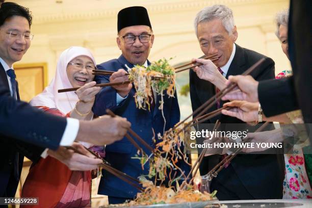 Singapore Deputy Prime Minister Lawrence Wong , Malaysian Prime Minister Anwar Ibrahim and his wife Wan Azizah , Singapore's Prime Minister Lee Hsien...