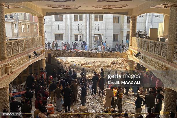 Security officials inspect the site of a mosque blast inside the police headquarters in Peshawar on January 30, 2023. - At least 17 people were...