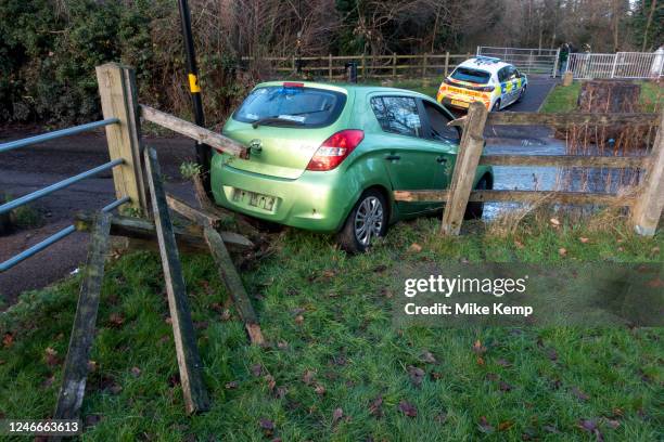 Stolen car which has driven through a fence in a park is attended to by a police car on 9th January 2022 in Birmingham, United Kingdom.