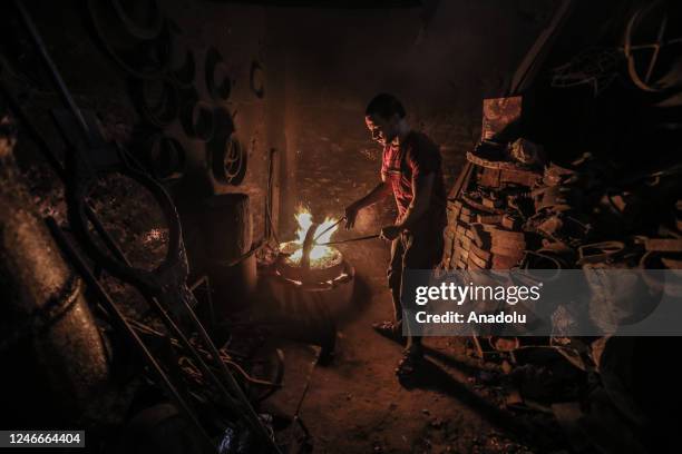 Casting workers melt scrap metal at a foundry workshop in Alexandria, Egypt on January 19, 2023. Workers melt and reshape used metals in moulds at a...