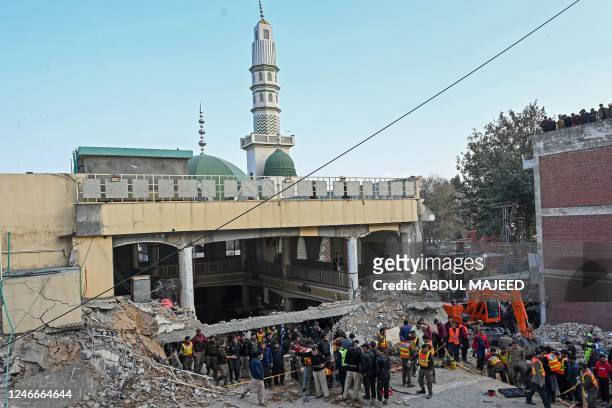 Security personnel and rescue workers prepare to search for the blast victims in the debris of a damaged mosque inside the police headquarters in...