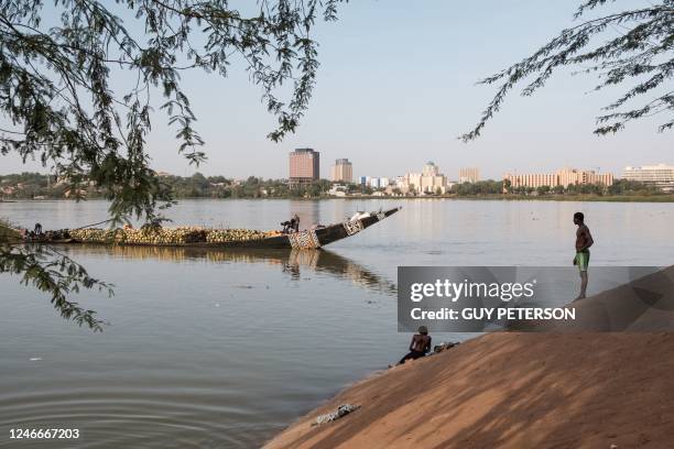 Men swim along the banks of the Niger River in Niamey on January 15, 2023.