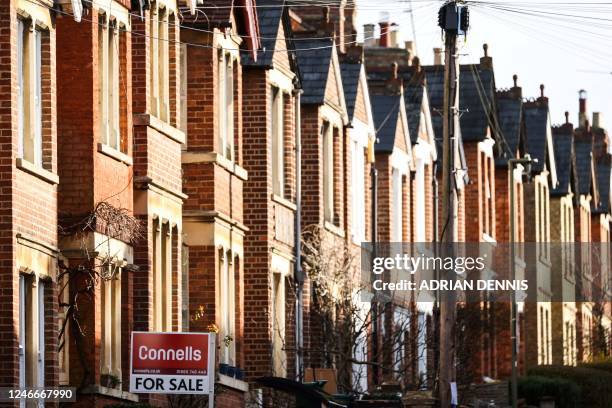 Photograph taken on January 30, 2023 shows a board reading "For Sale" on a building in the streets of Oxford.