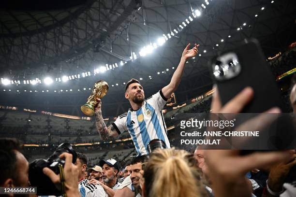 Argentina's captain and forward Lionel Messi holds the FIFA World Cup Trophy following the trophy ceremony after Argentina won the Qatar 2022 World...