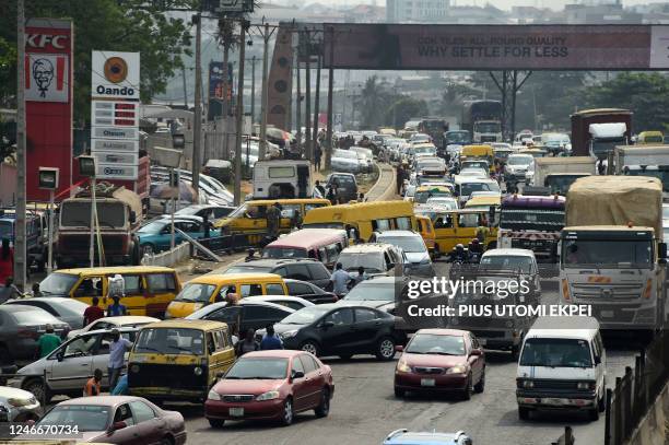 Drivers wait in line to buy fuel at and next to a filling station, causing traffic gridlock on Lagos' Ibadan expressway, in Lagos on January 30,...