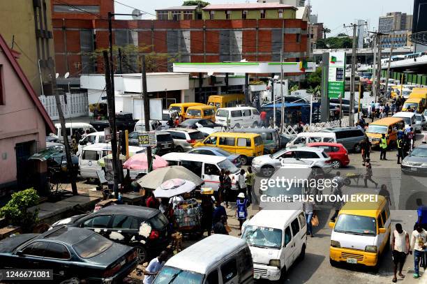 Drivers wait in line to buy fuel at and next to a filling station, causing traffic gridlock at Obalende in Lagos on January 30, 2023. - Nigerians...