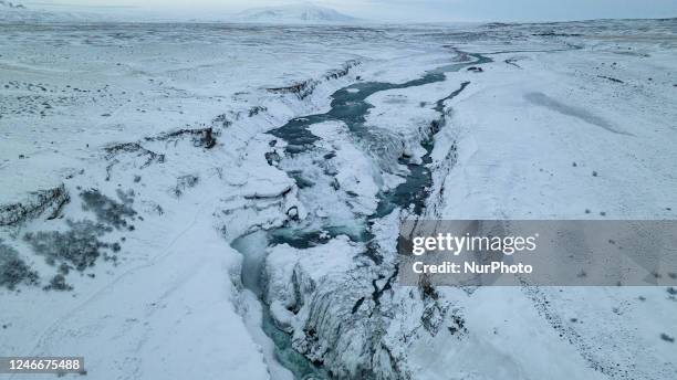 Drone view of snow covered Gullfoss Falls in Haukadalur Valley, Iceland, on January 23, 2023. -Gullfoss is one of Icelands most iconic waterfalls....