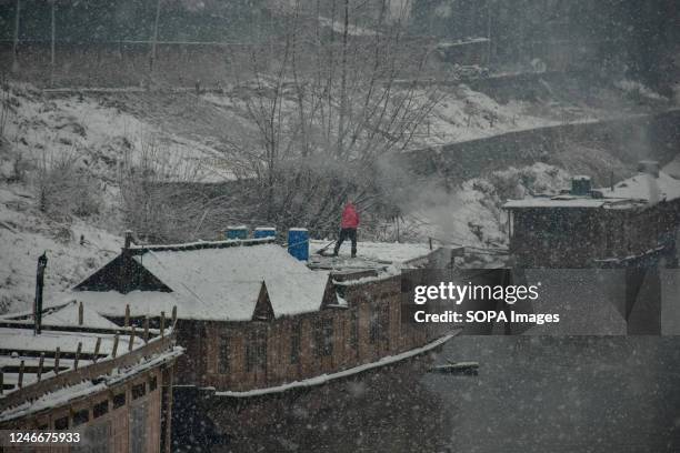 Man clears snow from his houseboat during snowfall in Srinagar. Kashmir valley was cut off from the outside world, with all flights to and fro...