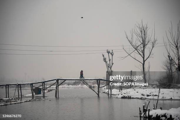 People walk on snow covered bridge during snowfall in Srinagar. The Kashmir valley received a fresh snowfall which disrupted the normal life of...