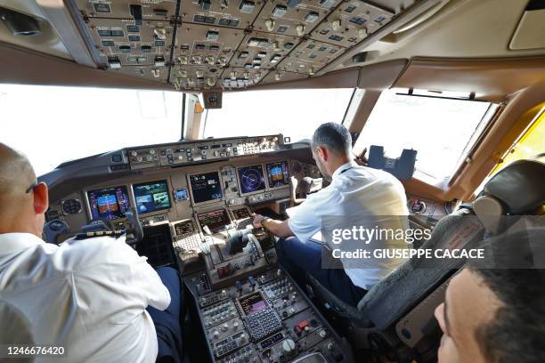Pilots sit in the cockpit of an Emirates Boeing 777-300ER aircraft, powering one of its engines with a hundred per cent Sustainable Aviation Fuel ,...