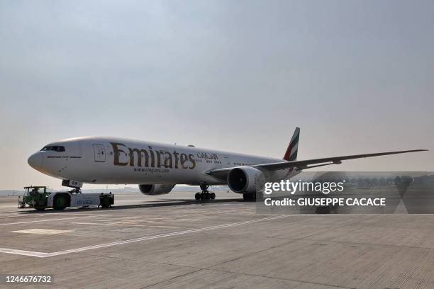 Ground crews prepare an Emirates Boeing 777-300ER aircraft, powering one of its engines with a hundred per cent Sustainable Aviation Fuel , for a...
